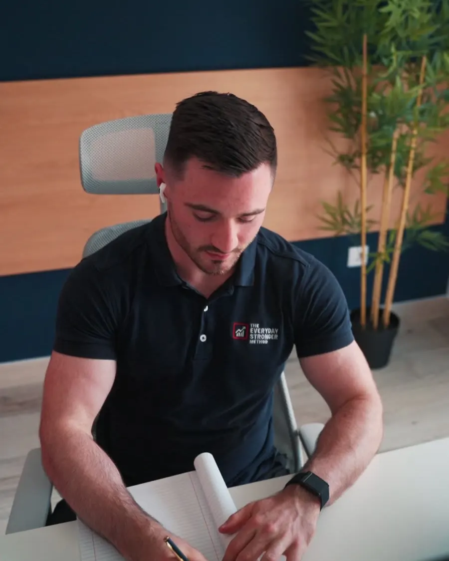 Eoin Kealy writing a client's training plan at his desk